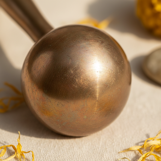 Close-up of Kansa bronze wand massager head showing metallic texture